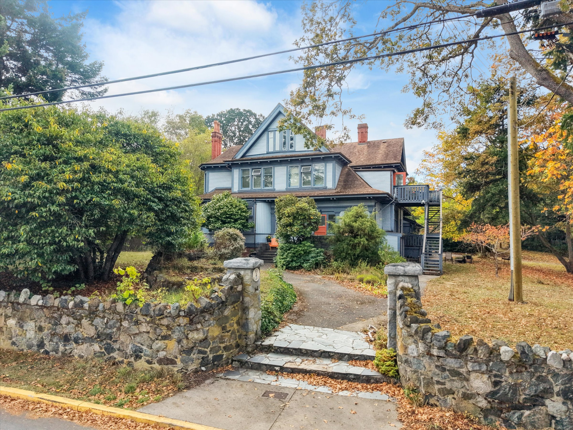 The 1904 heritage house behind its original stone wall on Pemberton Road